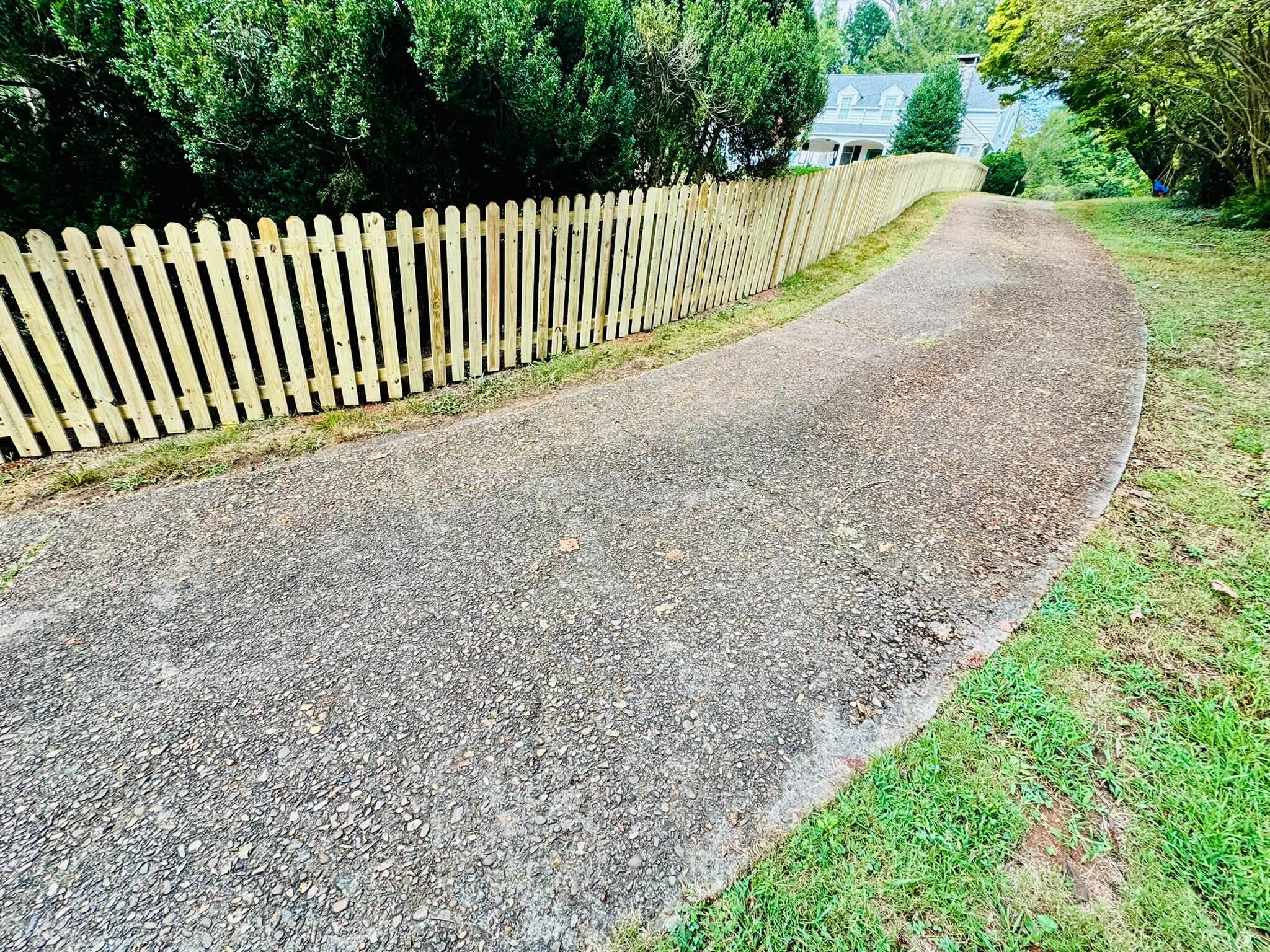 New wood picket fence along a driveway built by Athens Fence Company in Athens, Tennessee